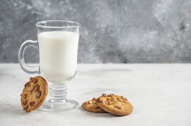 Bir bardak taze süt ve mermer zemin üzerinde lezzetli bisküviler. Yüksek kalite fotoğraf