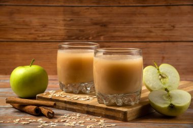 Bir bardak tarçınlı elma suyu ve ahşap arka planda anason.