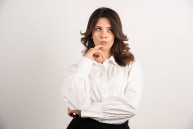 Genç çalışan beyaz arka plandaki işi düşünüyor. Yüksek kalite fotoğraf