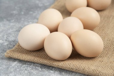 Mermer yüzeyinde masa örtüsü olan pişmemiş organik yumurta yığını. Yüksek kalite fotoğraf