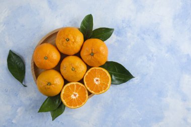 Tahta tabakta yaprakları olan mandalina mandalinalarının üst görüntüsü. Yüksek kalite fotoğraf