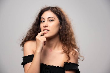 Siyah bluz giymiş kıvırcık saçlı genç bir kadın. Yüksek kalite fotoğraf