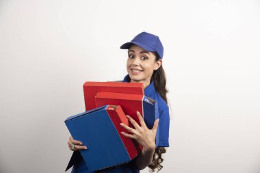 Kadın kurye pizza kartonuna sarılıyor ve elinde bir pano tutuyor. Yüksek kalite fotoğraf