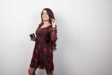 Gri arka planda fincanla poz veren kırmızı elbiseli genç kız. Yüksek kalite fotoğraf