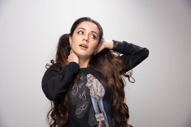 Genç bir kadın boynunu tutuyor ve ona bakıyor. Yüksek kalite fotoğraf