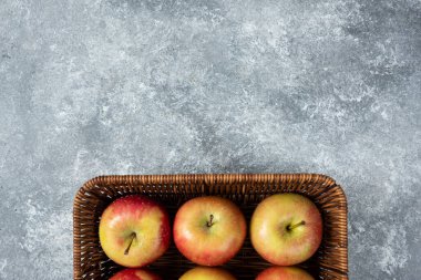 Mermer yüzeyde sulu elmalarla dolu bir sepet. Yüksek kalite fotoğraf