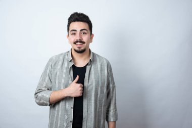 Sıradan giyinmiş genç bir adamın portresi ayakta ve başparmak kaldırıyor. Yüksek kalite fotoğraf