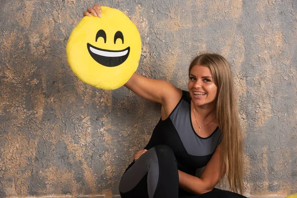 Menina Esportiva Jovem Roupas Esportivas Segurando Travesseiro Emoji Sorridente Acima — Fotografia de Stock