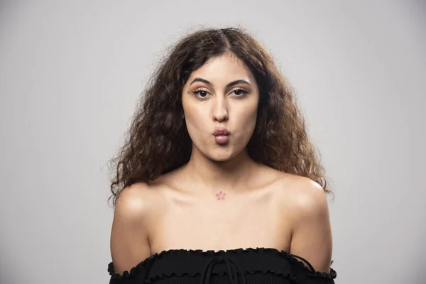 巻き毛で黒のブラウスに身を包んだ若い女性 高品質の写真 — ストック写真