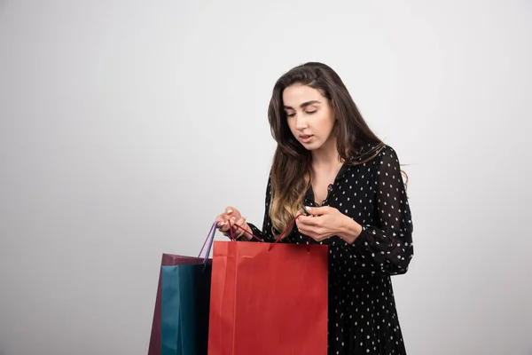 Jonge Vrouw Model Zoek Naar Winkeltassen Een Witte Achtergrond Hoge — Stockfoto