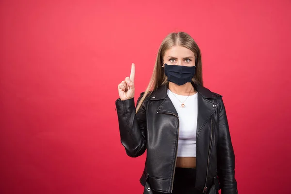 Hermosa Joven Con Una Mascarilla Médica Apuntando Hacia Arriba Foto — Foto de Stock