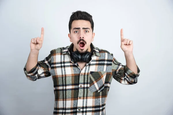 Imagen Hombre Guapo Con Auriculares Apuntando Sobre Una Pared Blanca —  Fotos de Stock