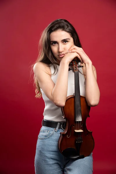 Jovem Modelo Abraçando Violino Fundo Vermelho Foto Alta Qualidade — Fotografia de Stock