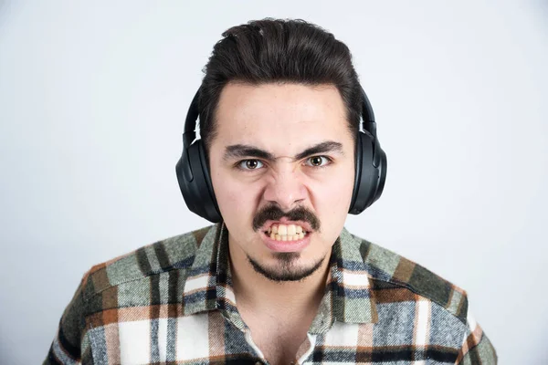 Kulaklıklı Yakışıklı Bir Adamın Beyaz Duvardan Kızgın Bakışları Yüksek Kalite — Stok fotoğraf