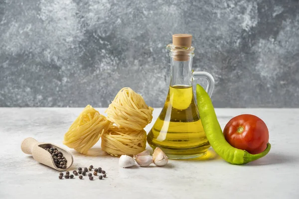 Rauwe Pasta Nesten Fles Olijfolie Peperkorrels Groenten Witte Tafel Hoge — Stockfoto