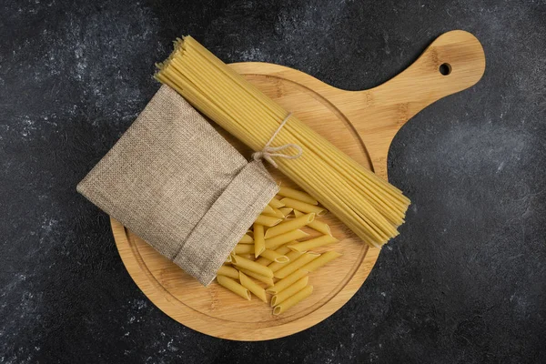 Massa Penne Uma Cesta Rústica Com Espaguetes Uma Bandeja Madeira — Fotografia de Stock