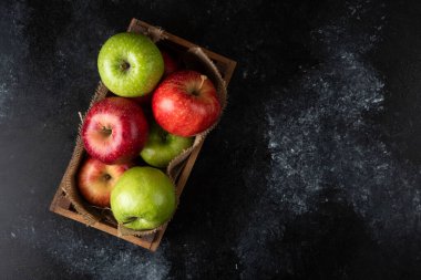 Siyah arka planda olgun organik elmalarla dolu tahta bir kutu. Yüksek kalite fotoğraf