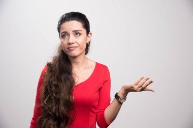 Kafası karışmış kırmızı elbiseli bir kızın portresi. Kameraya bakıyor.