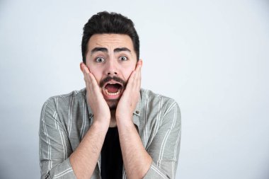 Sıradan giyinmiş, ayakta duran ve şaşırmış görünen genç bir adamın portresi. Yüksek kalite fotoğraf