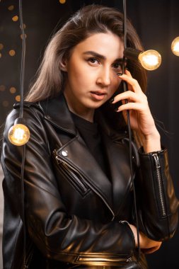 Lambaların yanında poz veren siyah deri ceketli güzel bir mankenin portresi. Yüksek kalite fotoğraf