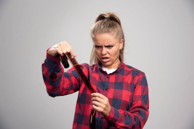 Kontrol edilmiş gömlekli sarışın model polaroid filmleri kontrol ediyor ve tatmin olmamış görünüyor. Yüksek kalite fotoğraf