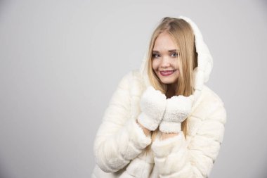 Kürklü mutlu kadın gri arka planda duruyor. Yüksek kalite fotoğraf