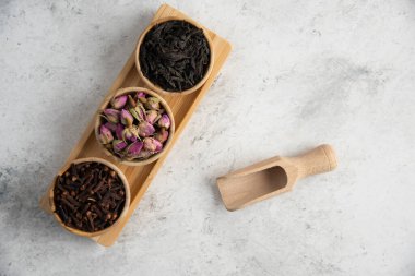 Tahta bir tahtanın üzerinde kurumuş güller ve aşılanmış ahşap kaseler. Yüksek kalite fotoğraf