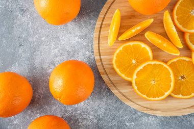 Taş zemin üzerinde portakal suyu dilimleriyle dolu tahta bir tahta. Yüksek kalite fotoğraf