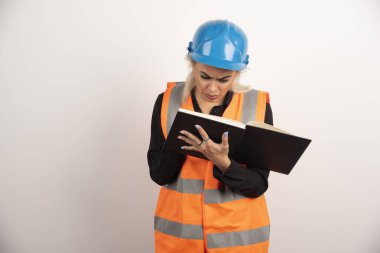 Memnuniyetsiz işçi beyaz arka plandaki önemli notları kontrol ediyor. Yüksek kalite fotoğraf