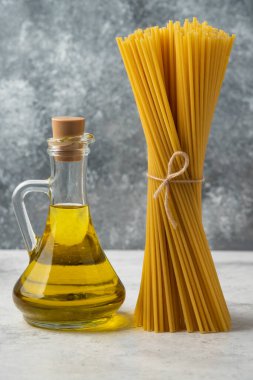 Beyaz masada kurutulmuş spagetti ve bir şişe zeytinyağı. Yüksek kalite fotoğraf