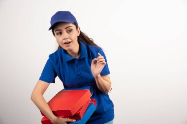 Üniformalı, gülümseyen ve pizza getiren genç bir kadının portresi. Yüksek kalite fotoğraf