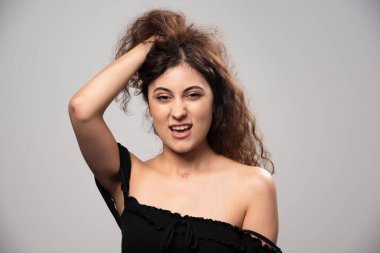 Siyah bluz giymiş kıvırcık saçlı genç bir kadın. Yüksek kalite fotoğraf