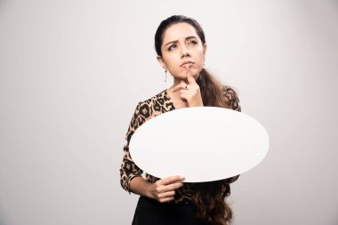 Leopar desenli tişörtlü iş kadını elinde yuvarlak bir düşünce tahtası tutuyor. Yüksek kalite fotoğraf