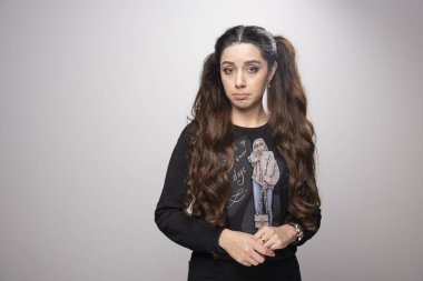 Gri arka planda üzgün hisseden genç bir kızın portresi. Yüksek kalite fotoğraf