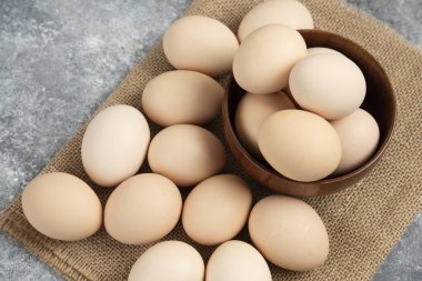 Mermer yüzeyde tahtadan bir kase organik çiğ yumurta. Yüksek kalite fotoğraf