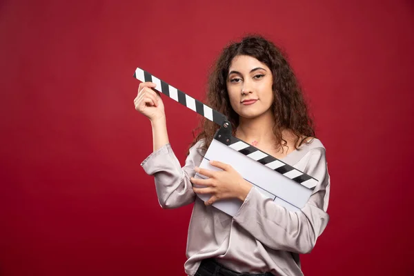 Lockigt Hår Kvinna Som Håller Clapperboard Röd Bakgrund Högkvalitativt Foto — Stockfoto