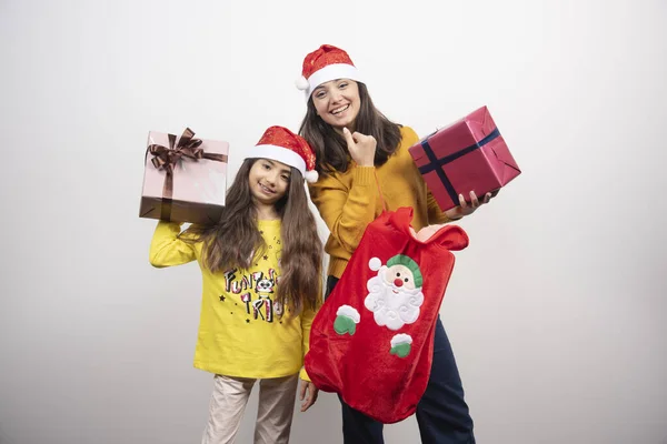 Дві Молоді Дівчата Різдвяними Подарунками Стоять Над Білою Стіною Високоякісна — стокове фото