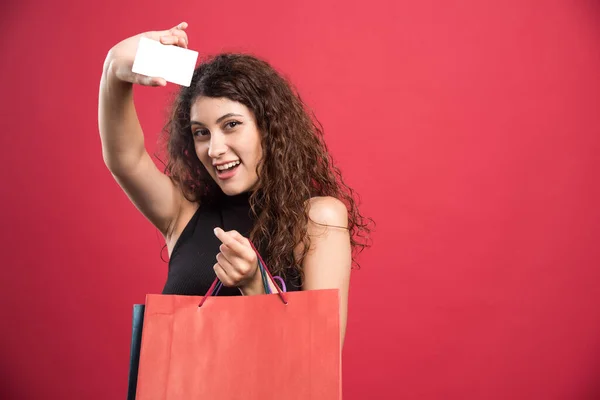 Gelukkige Vrouw Met Veel Tassen Bankkaart Rode Achtergrond — Stockfoto