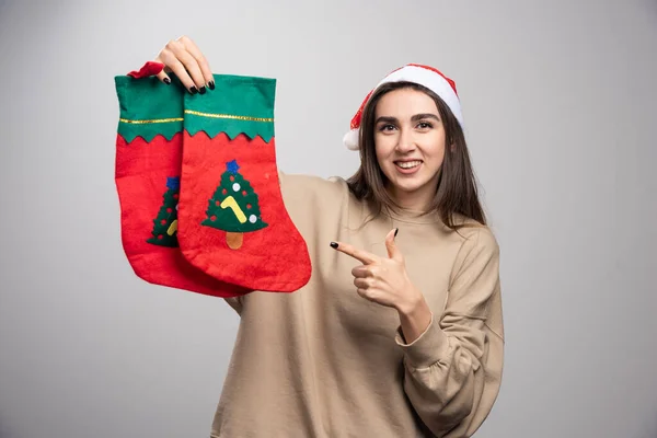 Jeune Fille Dans Chapeau Père Noël Pointant Vers Deux Chaussettes — Photo