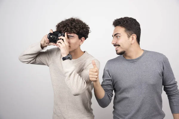 Two young men taking pictures with camera . High quality photo