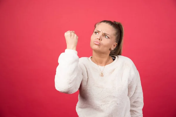 Mladá Žena Ukazuje Pěst Červené Stěně Kvalitní Fotografie — Stock fotografie