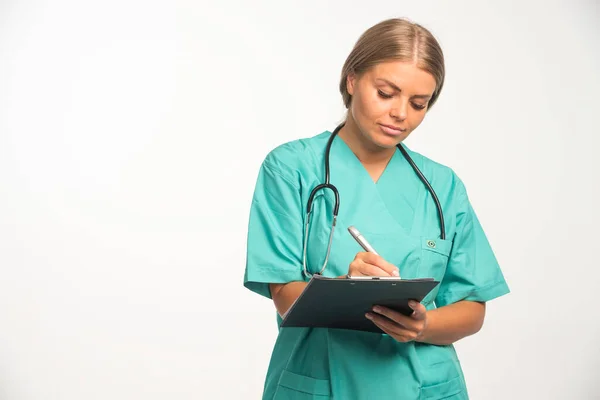 Blond Kvinnlig Läkare Blå Uniform Med Stetoskop Halsen Skriver Ett — Stockfoto