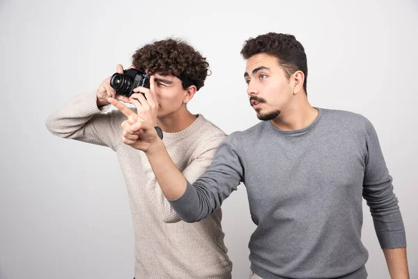 Two young men taking pictures with camera . High quality photo