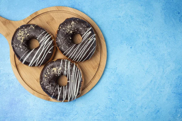 Три Шоколадных Пончика Деревянной Тарелке Синем Фоне Высокое Качество Фото — стоковое фото