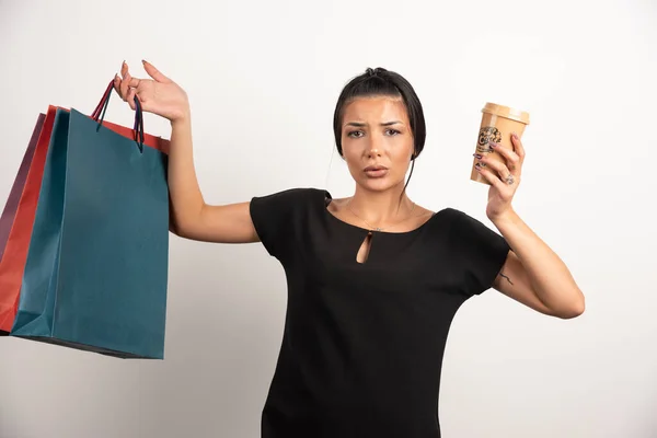 Vrouw Met Koffie Boodschappentassen Voelt Zich Verloren Een Witte Achtergrond — Stockfoto