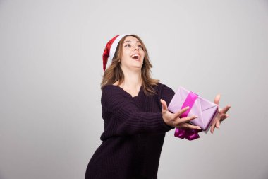 Noel Baba şapkalı genç bir kadın elinde bir hediye kutusu tutuyor. Yüksek kalite fotoğraf