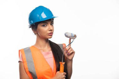 Beyaz arka planda boya silindiri olan kadın ressam ya da inşaatçı. Yüksek kalite fotoğraf