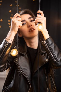 Lambaların yanında poz veren siyah deri ceketli güzel bir mankenin portresi. Yüksek kalite fotoğraf