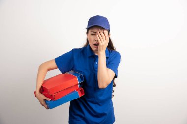 Elinde bir sürü pizza ve dosya olan genç bir kurye. 