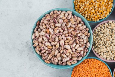 Bir sürü pişmemiş fasulye, mısır ve mermer yüzeyde kırmızı mercimek. Yüksek kalite fotoğraf